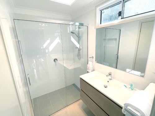 a bathroom with a shower and a sink at Fingal Bay Holiday Park in Fingal Bay