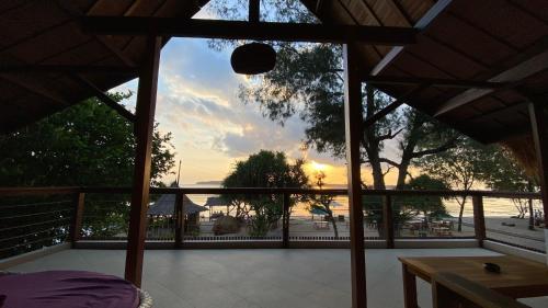 a screened in porch with a view of a sunset at Vyaana Resort Gili Air in Gili Air