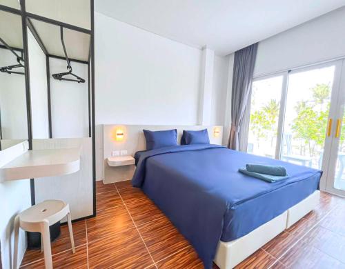 a bedroom with a blue bed and a desk at 88 House Patong in Patong Beach