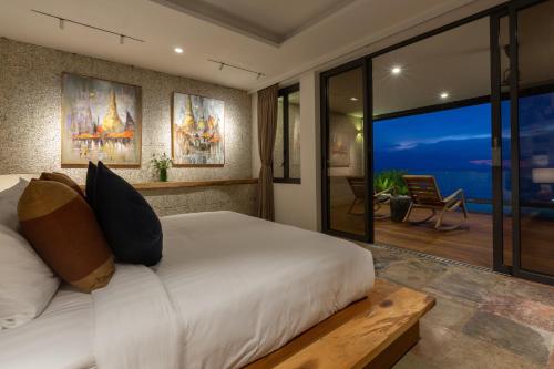 a bedroom with a bed with a view of the ocean at Villa U - Beachfront Haven in Lipa Noi