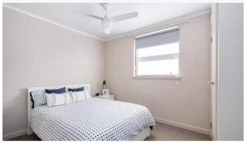 a white bedroom with a bed and a window at Kalgoorlie Central Accommodation in Kalgoorlie