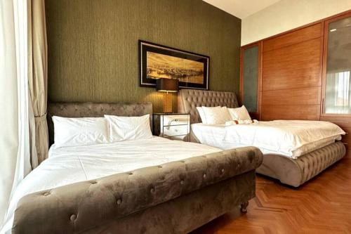 a bedroom with two beds and a couch in it at Cozy Straits Quay Seafront Suite in Tanjong Tokong