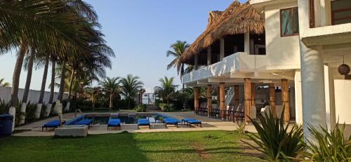 a villa with a swimming pool and palm trees at QUINTA DIAMANTE villas&hotel in Barra Vieja