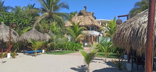 a resort on the beach with palm trees at QUINTA DIAMANTE villas&hotel in Barra Vieja
