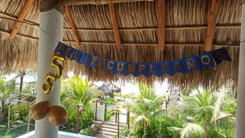 a birthday banner hanging from a straw roof at QUINTA DIAMANTE villas&hotel in Barra Vieja