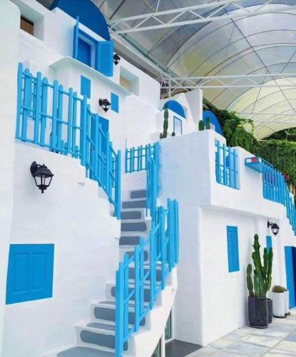 a blue and white building with blue windows and stairs at Sweet Homestay 3RM @ Penthouse Apartment in Brinchang in Brinchang