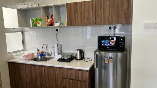 kuchnia z lodówką ze stali nierdzewnej i zlewozmywakiem w obiekcie Sweet Homestay 3RM @ Penthouse Apartment in Brinchang w mieście Brinchang