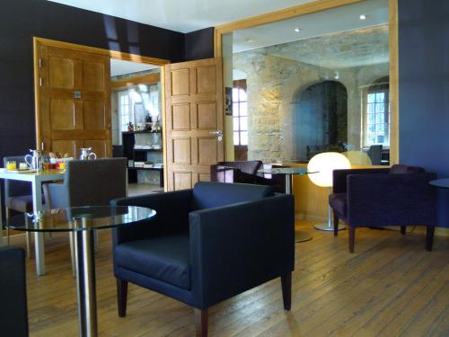 un restaurant avec une table, des chaises et un miroir dans l'établissement Hotel Le Temps De Vivre, à Roscoff