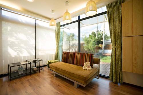 a living room with a couch and a large window at Squirrel House in Guanshan