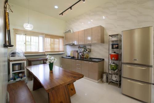 a kitchen with a wooden table and a refrigerator at Squirrel House in Guanshan