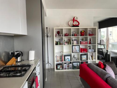 Una cocina y una sala de estar con un sofá rojo. en Radiance - Chic Fitzroy Street Apartment, en Melbourne