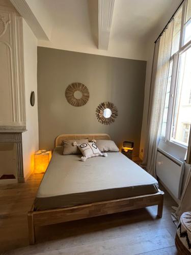 - une chambre avec un grand lit et deux miroirs sur le mur dans l'établissement Le Cocon Aixois, à Aix-en-Provence