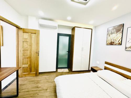 een slaapkamer met een bed, een bureau en een deur bij Thai Van Home in Ho Chi Minh-stad