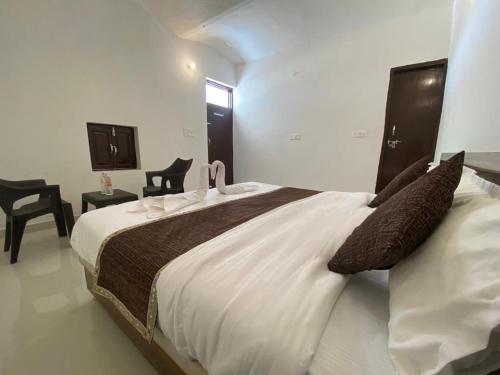 a bedroom with a large white bed with two swans on it at Mariyan Desert Safari Camp in Sām