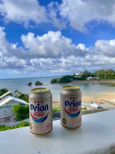 two cans of orion life drink sitting on a table overlooking the ocean at Aqua shallows in Onna