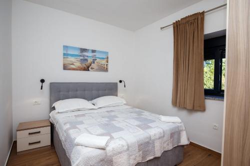 Un dormitorio con una cama grande y una ventana en Villa MiEma with Jacuzzi, en Zadar