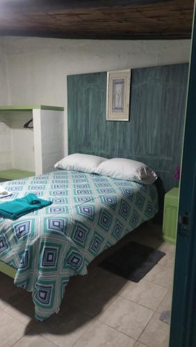 a bedroom with a bed with a blue and green comforter at Finca San Alejandro in Cotacachi