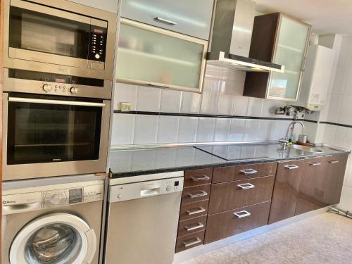 a kitchen with a washer and a washing machine at Chalet Lujo Logroño in Agoncillo