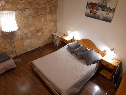 1 dormitorio con 1 cama con almohadas y 2 lámparas en 3Cities Maison close to Valletta, en Cospicua