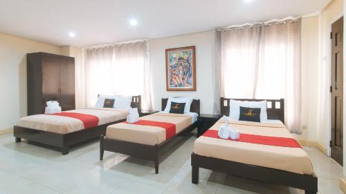 three beds in a room with windows at 153 Silverio Suites Betterliving Paranaque in Manila