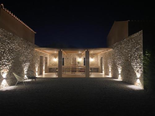 una casa con una pared de piedra por la noche en Inspiro Retreat Mani, 