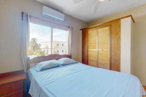 1 dormitorio con cama y ventana grande en De Real Macaw, en Caye Caulker