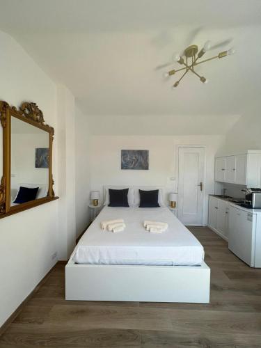 a white bedroom with a bed and a ceiling fan at Fior di Loto Suite - Lingotto in Turin