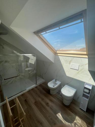 a bathroom with a shower and a toilet and a window at Fior di Loto Suite - Lingotto in Turin