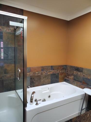 a bathroom with a tub and a glass shower at Elegant, Sunny Modern Home with Skylights - Kitsilano, Vancouver in Vancouver