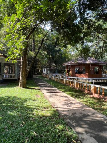 un chemin dans un parc à côté d'une maison dans l'établissement Surya Eco and Wedding Resort, à Thrissur