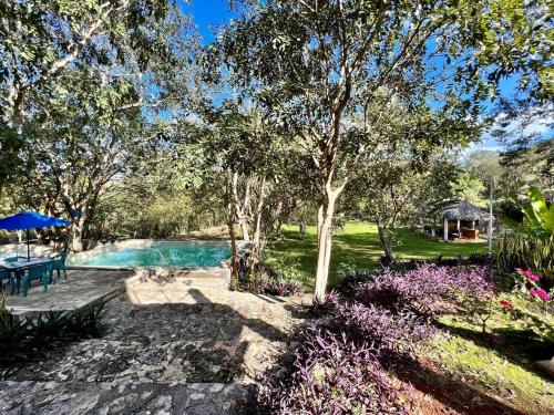 a swimming pool in a yard with trees and flowers at El Encanto - Hotel Boutique in Chichén-Itzá