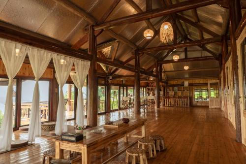 Moc Home Sapa في سابا: غرفة كبيرة مع أرضيات خشبية وسقف خشبي