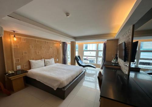 a bedroom with a bed and a desk with a television at UPAR Hotels Sukhumvit 11 Nana in Bangkok