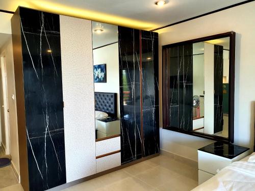 um quarto com armários de vidro preto e um espelho em Sea Sand Sun Resort em Rayong