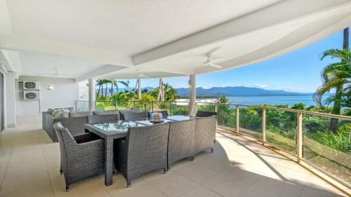 a dining room with a view of the ocean at Island Point Villa 1 Port Douglas in Port Douglas