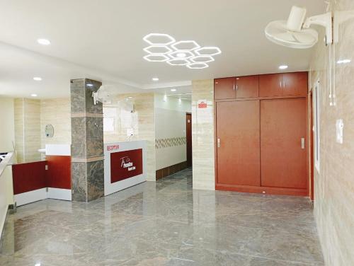 a lobby with a hallway with red doors and marble floors at The Paradise Guest Inn in Nellore