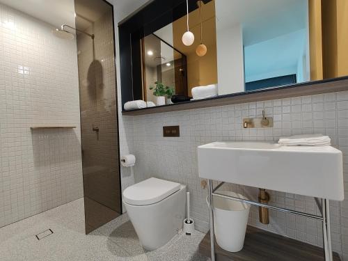 La salle de bains est pourvue de toilettes, d'un lavabo et d'un miroir. dans l'établissement Swanston Central 17, à Melbourne
