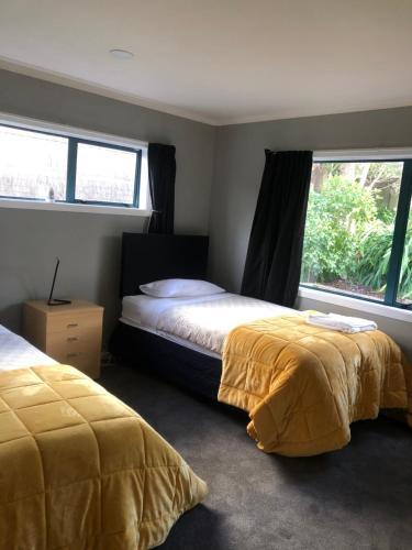 a bedroom with two beds and a window at Observation Holiday Home in Paraparaumu Beach