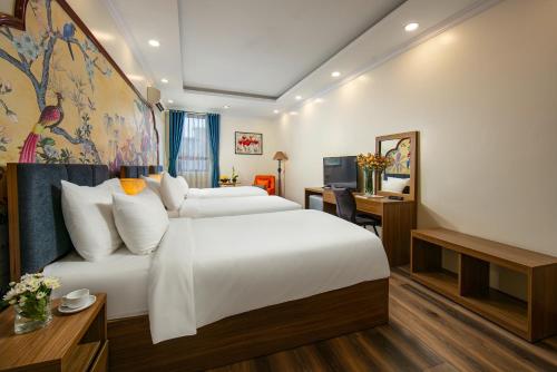 a hotel room with a large bed and a desk at The Sono Hanoi Hotel in Hanoi
