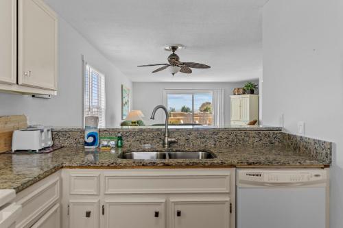 a kitchen with a sink and a ceiling fan at Bayview East & West in Holden Beach