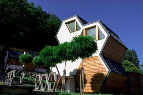 une maison avec un arbre en face dans l'établissement Honeycomb Chalets And Apartments Mozirje - Happy Rentals, à Mozirje