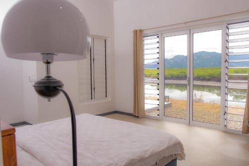 a bedroom with a bed and a large window at Lake Side Villa in Nadi