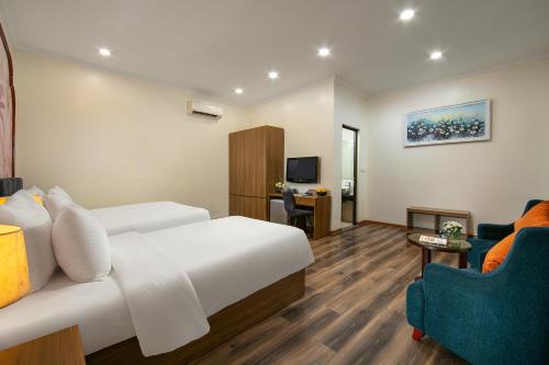 a hotel room with a bed and a couch and a tv at The Sono Hanoi Hotel in Hanoi