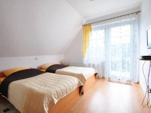a bedroom with two beds and a window at domek PERKUN in Pierkunowo