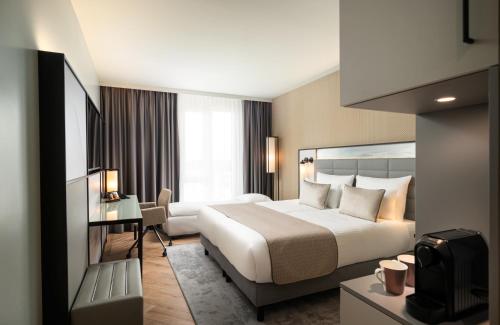 a hotel room with a bed and a desk at Leonardo Royal Hotel Cologne Bonn Airport in Cologne