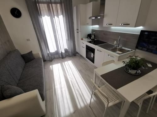 cocina y sala de estar con mesa y sofá en Trinity Apartment, en Catania