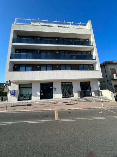 a tall white building on the side of a street at Donati Business Rooms in Subbiano