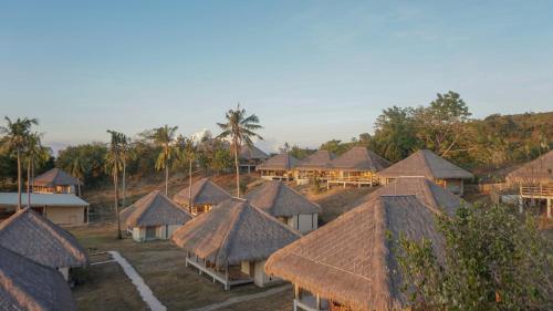 an aerial view of a group of houses with thatched roofs at Bleu MATHIS Gili Asahan in Gili Asahan