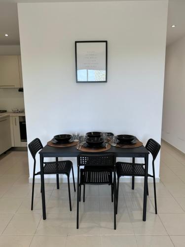 uma mesa preta com cadeiras e uma imagem na parede em Appartement en résidence em La Ciotat