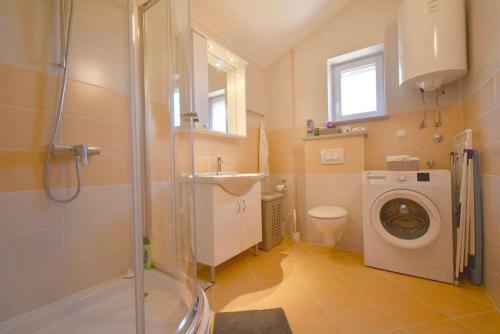 a bathroom with a washing machine and a sink at Apartment with sea View Klimno No 5 in Dobrinj